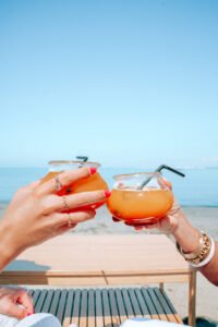 Deux cocktails port&eacute;s en toast sur fond de mer &agrave; La R&eacute;serve Plage, Grau du Roi