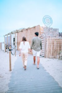 Couple entrant &agrave; La R&eacute;serve Plage en marchant sur un chemin en bois au Grau du Roi